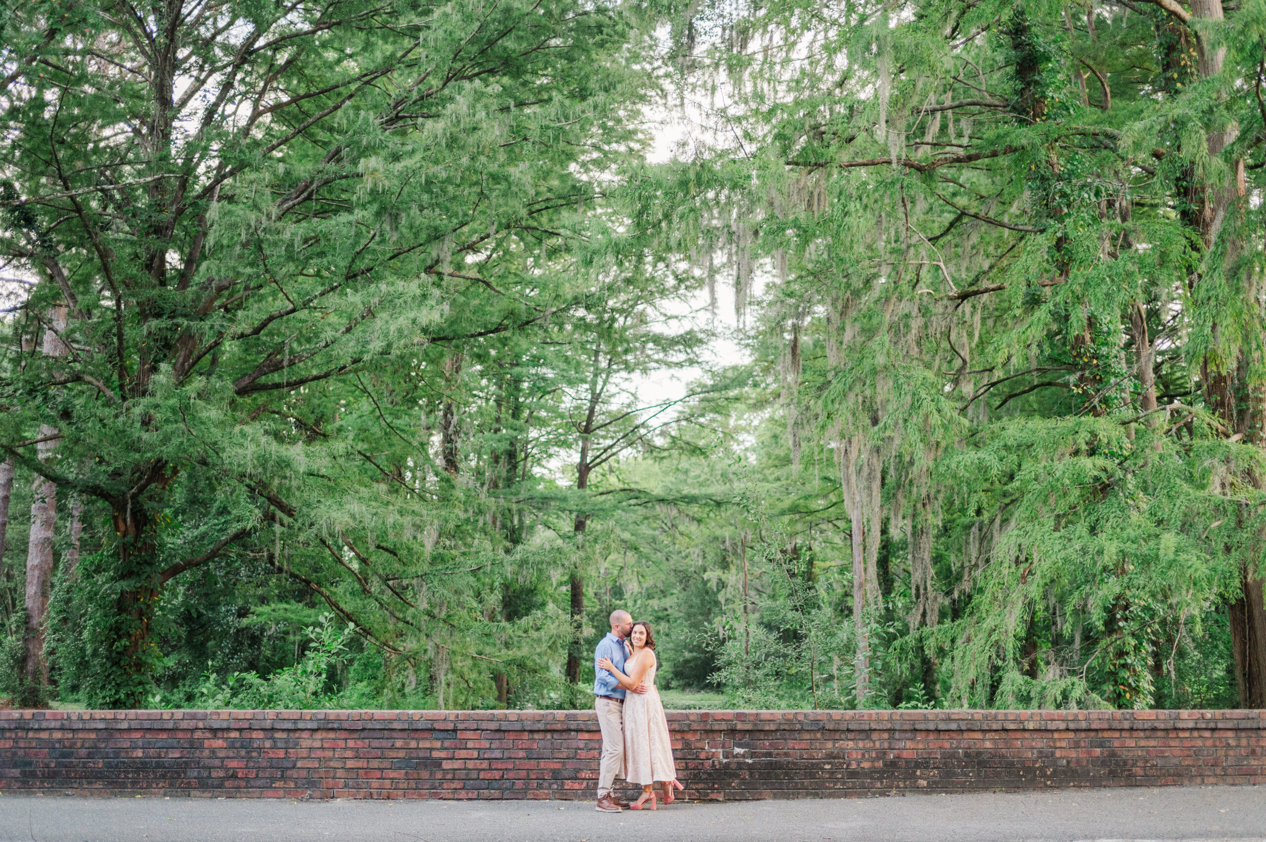 An engaged couple in Wilmington, North Carolina during their engagement photos in Greenfield Lake Park.