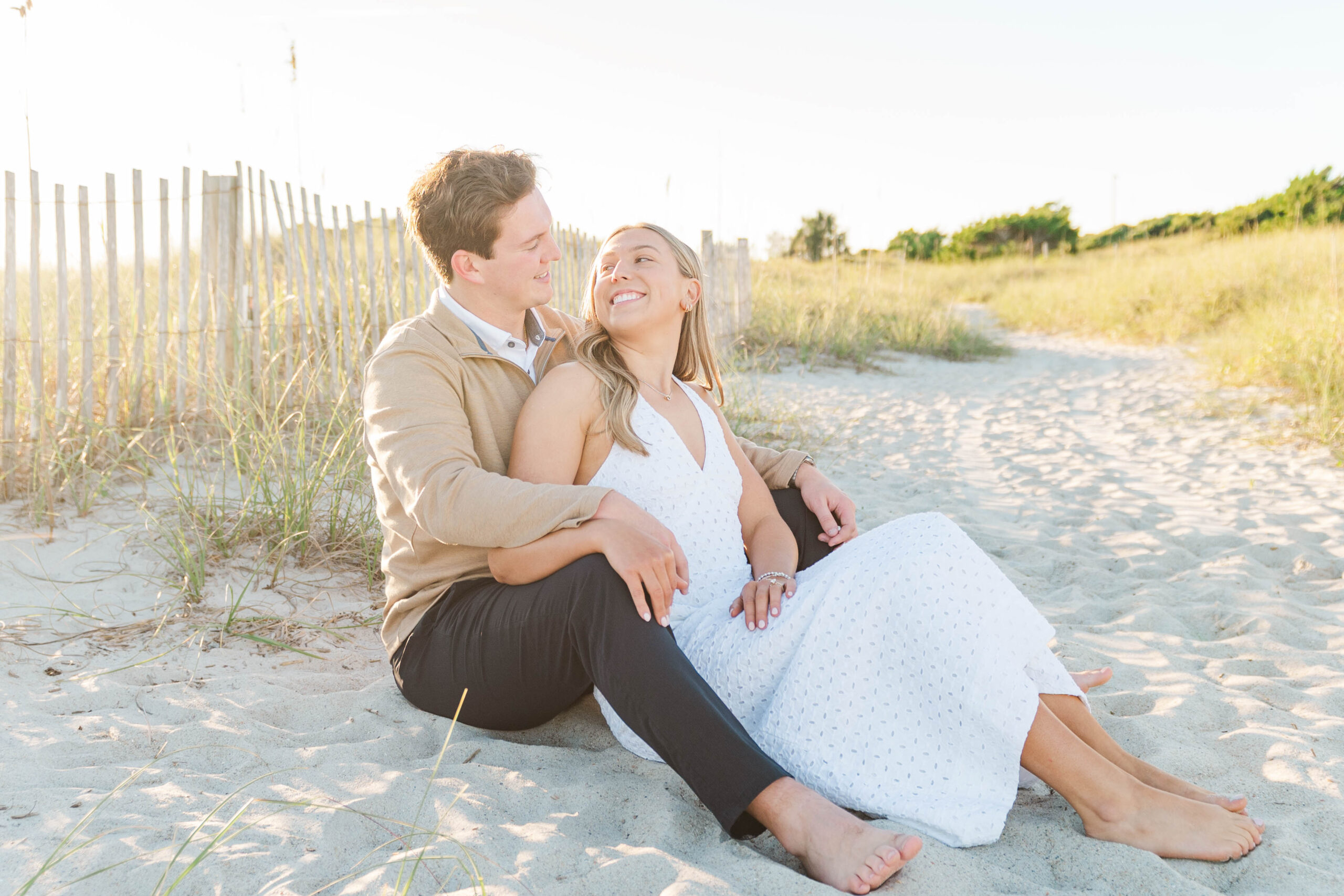 couple smiling at each other during their engagement session at Wrightsville Beach, NC