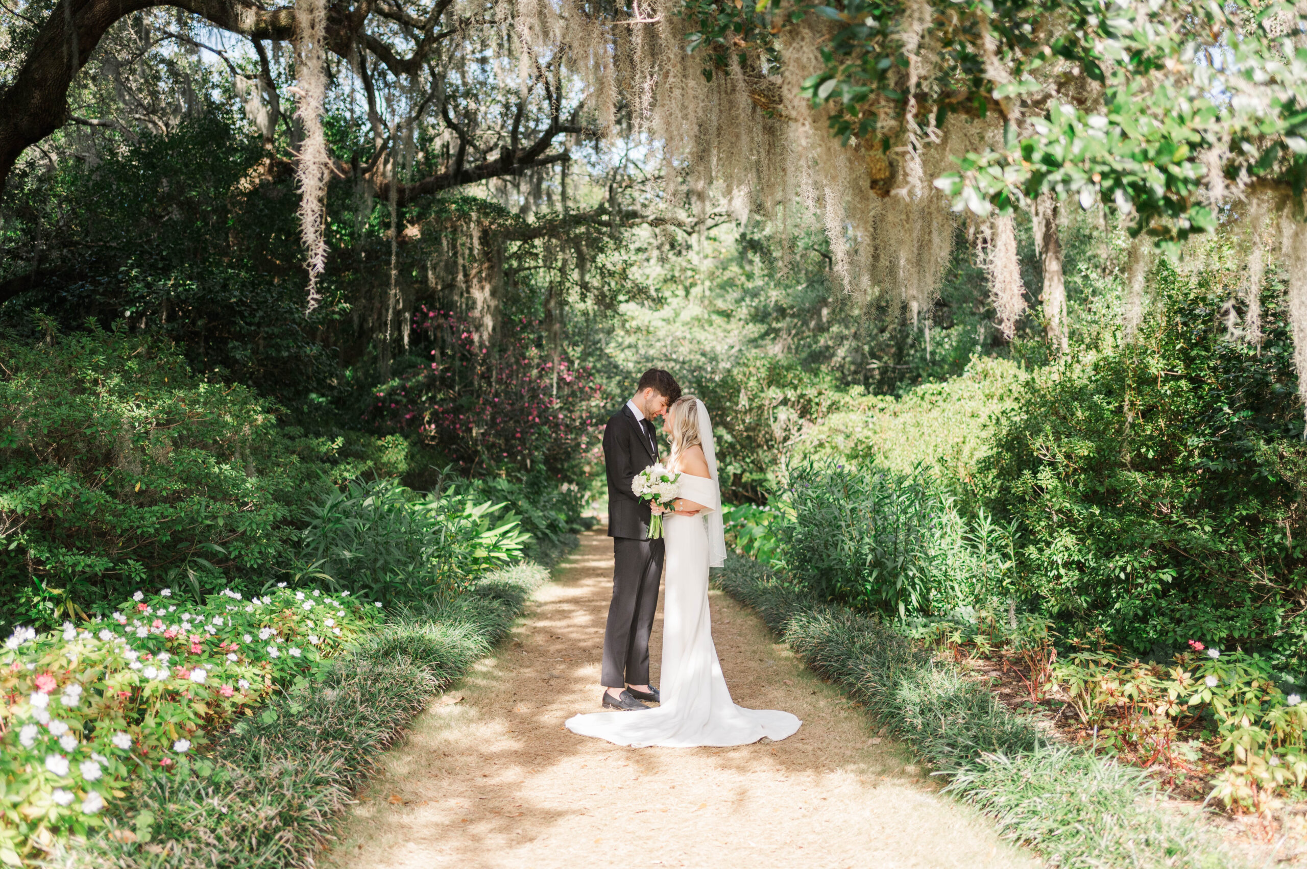 Groom whispering to bride during intimate Raleigh, NC Airlie Gardens elopement.